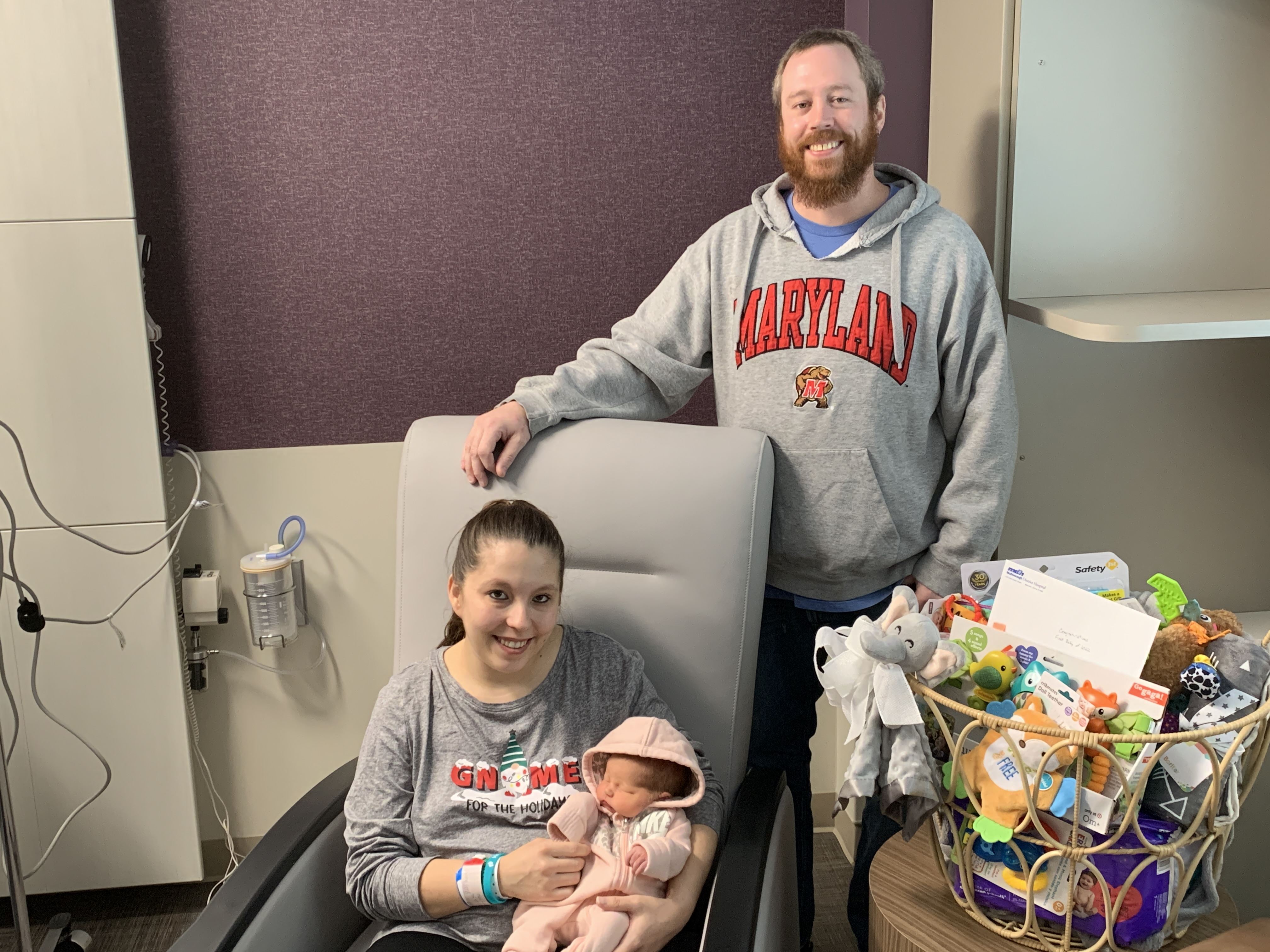 mom and dad and new baby with basket of gifts