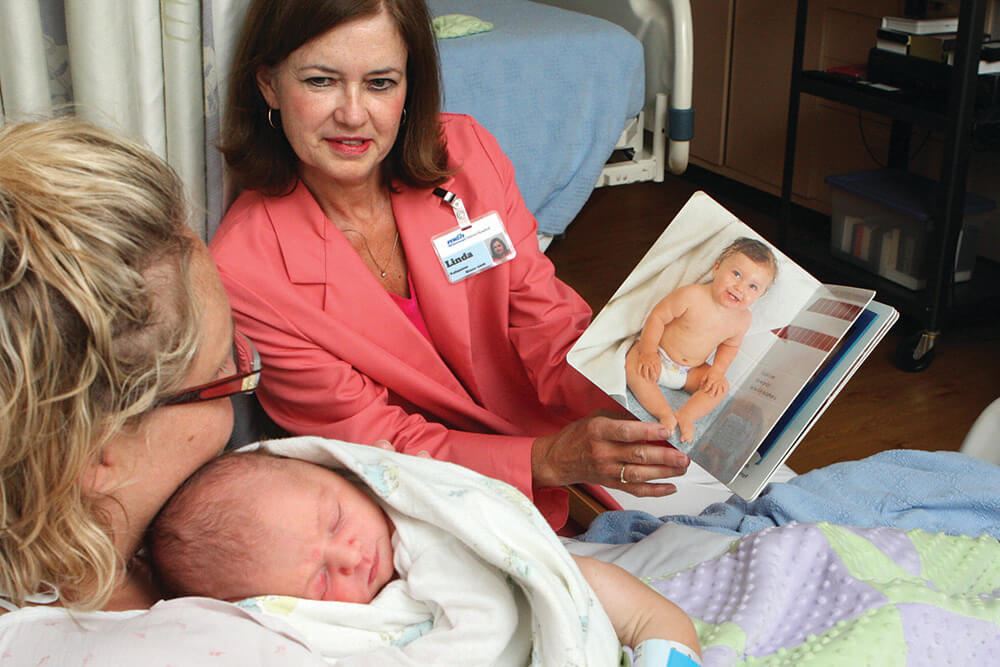 woman reading to mother and baby